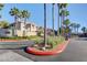 View of community entrance with stone wall, mature palms, and signage at 9901 Trailwood Dr # 2007, Las Vegas, NV 89134