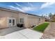 A view of the backyard with grass, and a patio area accessible through a double door at 1069 Appleblossom Time Ave, North Las Vegas, NV 89031