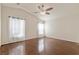 Bright bedroom with hardwood floors, ceiling fan, and sheer white curtains at 1069 Appleblossom Time Ave, North Las Vegas, NV 89031