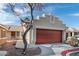 Home exterior featuring a two-car garage and desert landscaping under a partly cloudy sky at 1069 Appleblossom Time Ave, North Las Vegas, NV 89031