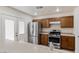 Kitchen featuring stainless steel appliances, wood cabinets, and access to the backyard at 1069 Appleblossom Time Ave, North Las Vegas, NV 89031