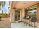 Covered patio with chairs and table, with the house's sliding door entryway at 10960 Prairie Grove Rd, Las Vegas, NV 89179