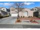 Two-story house exterior with a white garage door and manicured lawn at 1551 Boundary Peak Way, Las Vegas, NV 89135