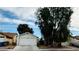House exterior view with a two-car garage and mature tree in front at 1825 Ann Greta Dr, Las Vegas, NV 89108