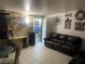 Cozy living room with neutral walls, tile floors, dark leather sofa, and decorative wall art at 1901 Belmont St, North Las Vegas, NV 89030