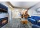 Open-concept living room with a fireplace, cozy blue sofa, and seamless transition to the kitchen at 211 E Flamingo Rd # 412, Las Vegas, NV 89169