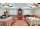 Spacious bedroom with hardwood floors, a ceiling fan, and natural light from the white shuttered windows at 2410 Doherty Way, Henderson, NV 89014