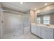 Bright bathroom featuring a glass shower and double sink vanity with white cabinets at 2436 Padulle Pl, Henderson, NV 89044