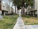 Exterior view of the townhouse complex with sidewalk and well-maintained landscaping at 2638 Aracatuba Ave, Las Vegas, NV 89121