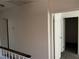Bright hallway featuring neutral walls, wood railing, and access to other rooms at 2638 Aracatuba Ave, Las Vegas, NV 89121