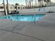 Community pool featuring a sparkling pool, concrete surround, metal fence, and palm trees at 2638 Aracatuba Ave, Las Vegas, NV 89121