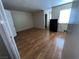 A vacant bedroom with wood floors, an open door, and a black dresser beneath a window at 2686 Ruthe Duarte Ave, Las Vegas, NV 89121