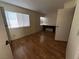A vacant bedroom featuring wood floors, two bright windows, and an open door at 2686 Ruthe Duarte Ave, Las Vegas, NV 89121