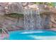 Circular pool with a waterfall feature, surrounded by rocks and greenery at 322 Karen Ave # 1903, Las Vegas, NV 89109