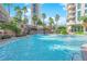 Resort-style pool with a large waterfall and palm trees at 322 Karen Ave # 1903, Las Vegas, NV 89109