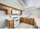 Galley-style kitchen with wood cabinets and white appliances at 3954 Edgemoor Way, Las Vegas, NV 89121