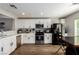 Modern kitchen with white cabinets, stainless steel appliances, and wood-look flooring at 4924 Conglobate St, Las Vegas, NV 89122
