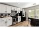 Modern kitchen with white cabinets, stainless steel appliances, and wood-look flooring at 4924 Conglobate St, Las Vegas, NV 89122