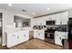 Modern kitchen with white cabinets, stainless steel appliances, and wood-look flooring at 4924 Conglobate St, Las Vegas, NV 89122