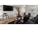 Living room with large TV, black furniture, and hardwood floors at 4924 Conglobate St, Las Vegas, NV 89122