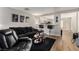 Spacious living room with black leather furniture and a view into the kitchen at 4924 Conglobate St, Las Vegas, NV 89122