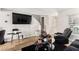 Living room with large TV, black furniture, and hardwood floors at 4924 Conglobate St, Las Vegas, NV 89122