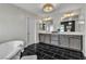 Luxurious bathroom featuring dual vanities, a soaking tub, and elegant tile work, offering a spa-like experience at 6276 Olde Lockford Ct, Las Vegas, NV 89139