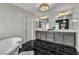 Elegant bathroom features a standalone tub, modern floor tiling and double sink vanity at 6276 Olde Lockford Ct, Las Vegas, NV 89139