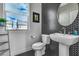 Contemporary powder room showcasing striking black and white tiling and a sleek pedestal sink at 6276 Olde Lockford Ct, Las Vegas, NV 89139