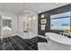 Elegant bathroom features a glass-enclosed shower, soaking tub, and black tiled floor at 6276 Olde Lockford Ct, Las Vegas, NV 89139