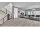 Open-concept living room with modern decor, tile flooring, and a staircase at 6276 Olde Lockford Ct, Las Vegas, NV 89139