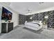 Spacious bedroom featuring a mounted TV, ceiling fan, and patterned accent wall at 6276 Olde Lockford Ct, Las Vegas, NV 89139