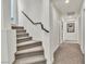 Carpeted staircase with a modern railing and bright lighting at 6276 Olde Lockford Ct, Las Vegas, NV 89139