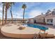 Large kidney shaped pool with spacious patio and palm trees at 7520 W Wigwam Ave, Las Vegas, NV 89113