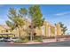 Tan two-story building with trees, parking, and gated entrance at 7950 W Flamingo Rd # 1054, Las Vegas, NV 89147