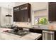 Modern kitchen boasts dark cabinetry, marble countertops, and a gas cooktop at 9113 Golden Eagle Dr, Las Vegas, NV 89134