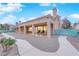 Back exterior of house featuring a covered patio, gravel yard, and lush green space with mature landscaping at 9609 Eagle Valley Dr, Las Vegas, NV 89134