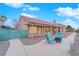 Back of the house featuring a covered patio, gravel yard, seating around a fire pit, and lush landscaping at 9609 Eagle Valley Dr, Las Vegas, NV 89134