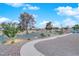 Scenic backyard features a gravel yard with landscaping, walkway, and view of a lush green space at 9609 Eagle Valley Dr, Las Vegas, NV 89134