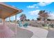 Covered patio area with a seating area overlooks a landscaped yard, featuring gravel and mature trees at 9609 Eagle Valley Dr, Las Vegas, NV 89134