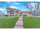 Beautiful single-story home featuring a red tile roof, arched window, and a well-manicured artificial turf lawn at 9609 Eagle Valley Dr, Las Vegas, NV 89134
