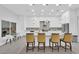 Bright kitchen boasts white cabinetry, modern stainless steel appliances, and an island with bar stool seating at 9609 Eagle Valley Dr, Las Vegas, NV 89134