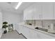 Modern laundry room with white cabinets, counter space, sink, and a washer and dryer at 9609 Eagle Valley Dr, Las Vegas, NV 89134