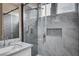 Modern bathroom with gray tile, marble vanity and a frameless shower at 10525 Findlay Ave, Las Vegas, NV 89134