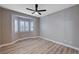 Bright bedroom with wood-look floors, window seat, and ceiling fan at 10525 Findlay Ave, Las Vegas, NV 89134