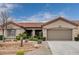 Single-story house with a two-car garage and landscaped front yard at 10525 Findlay Ave, Las Vegas, NV 89134