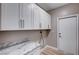 Bright laundry room with white cabinets and marble countertops at 10525 Findlay Ave, Las Vegas, NV 89134