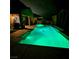 Nighttime view of a backyard pool and patio with lush greenery providing a serene outdoor oasis for relaxation at 1136 Buckhorn Cove St, Henderson, NV 89011