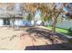 The backyard has gravel area, artifical turf, a trash can, privacy fence and mature trees at 1403 5Th Pl, Las Vegas, NV 89104