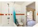 Bathroom featuring tiled walls, toilet, and a shower-tub combination at 1403 5Th Pl, Las Vegas, NV 89104